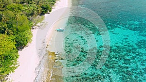 Aerial view. First tourist banca boat on tropical sandy beach. Helicopter island, El Nido, Palawan Philippines. Blue