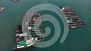 Aerial view of fish farm on the water near Lamma Island, Hong Kong. A boat is sailing nearby