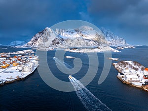 Aerial view of fishing boat in blue sea and snowy islands