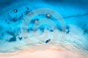 Aerial view of the fishing boat in clear blue water at sunset