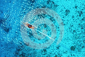 Aerial view of the fishing boat in transparent blue water