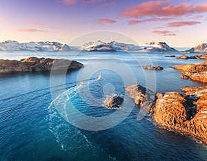 Aerial view of fishing boats, rocks in the blue sea