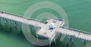 An aerial view of a fishing pier in Panama City Beach,Florida in the waters of the emerald green Gulf of Mexico