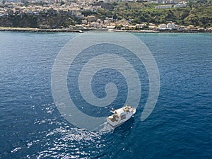 Aerial view of a fishing vessel in the blue sea off the coast of Calabria, Italy