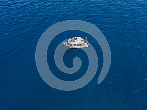 Aerial view of a fishing vessel in the blue sea off the coast of Calabria, Italy