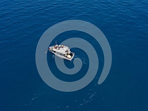 Aerial view of a fishing vessel in the blue sea off the coast of Calabria, Italy