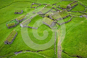 Aerial view of fishing village in Koltur island. Faroe Islands. Green roof houses. Photo made by drone from above. Nordic natural