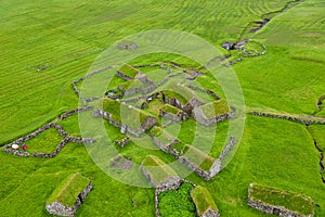 Aerial view of fishing village in Koltur island. Faroe Islands. Green roof houses. Photo made by drone from above. Nordic natural