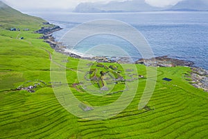 Aerial view of fishing village in Koltur island. Faroe Islands. Green roof houses. Photo made by drone from above. Nordic natural