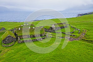 Aerial view of fishing village in Koltur island. Faroe Islands. Green roof houses. Photo made by drone from above. Nordic natural