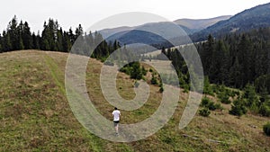 Aerial view of fit man running in mountains forest on weekend, amazing trail running moments, achieving fitness goals