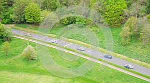 Aerial view of five cars driving in a countryside road