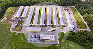 Aerial view  and flight along silos and agro-industrial livestock complex on agro-processing and manufacturing plant with modern g
