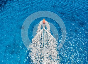 Aerial view of floating motorboat in transparent blue sea