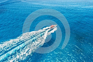Aerial view of floating motorboat in transparent blue sea