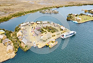 Aerial view of floating village in Uros islands at Titicaca lake in Peru - Wanderlust and travel concept - Cloudy aftrenoon