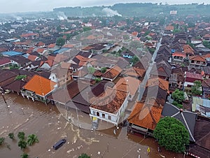 Aerial view of flooding city. Natural disaster damages houses and vehicles. Extreme flood and storm aerial photo.