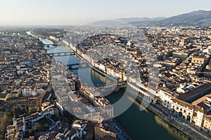 Aerial view of Florence skyline along Arno river at sunset with Ponte Vecchio bridge in foreground, Florence, Tuscany, Italy