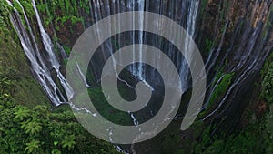 Aerial view fly through trees to Tumpak Sewu waterfall, East Java, Indonesia