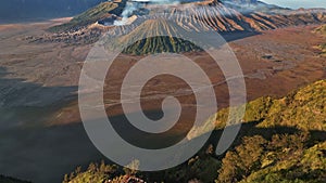 Aerial view flying backward and tilting up to reveal Bromo volcano, Indonesia