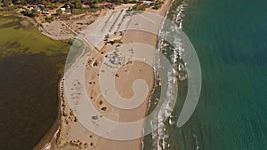 Aerial view flying over amazing white sand beach and tropical coral reef lagoon towards beautiful green mountains at