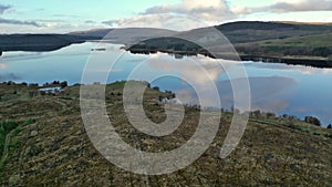 Aerial view: flying over fir trees towards Carron valley reservoir.