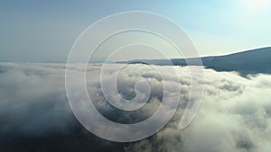 Aerial View. Flying over the high mountains in beautiful clouds . Aerial camera shot. Air clouds
