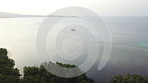 Aerial view of forest and Pinisi Ship in Indonesia