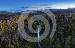 Aerial view of forest with red trees on mountain in fall in Slovakia. Colorful landscape. Top view from drone. Nature in october