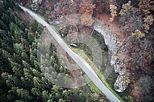 Aerial view of forest road in beautiful autumn. Colorful Trees in yellow, red and green from above.