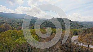 Aerial view of the forest. A road between the trees. And town on the mountain. Italy, Toskana