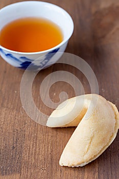 Aerial view of fortune cookie and Chinese cup with tea, on wooden table, with selective focus