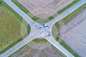 aerial view of the four-lane asphalt crossing between agricultural fields, crossroads of roads