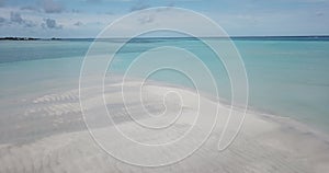 Aerial view of four people walking along sandy coast