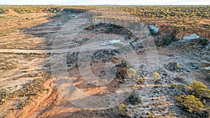 Aerial view of four wheel drive vehicle and large caravan camped just after sunrise in the outback of Australia