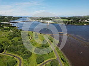 Aerial view of the Foyle Bridge in Londonderry, Northern Ireland with a calm river and lush greenery