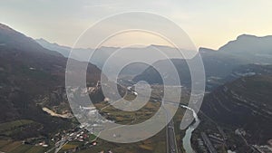 Aerial view of freeway interstate road in italian alps with fast moving traffic and rural green landscape.