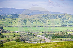 Aerial view of freeway junction and agricultural fields, mountain background, south San Francisco bay, San Jose, California