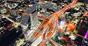 Aerial view freeway and street at night with fast driving cars and trucks in Miami city, Florida. View from above bright lights