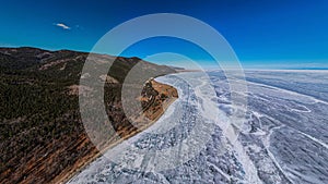 Aerial view of frozen lake Baikal in winter season, the surface of lake covered by huge snow