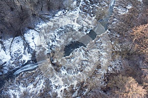 Aerial view on frozrn river in forest landscape in winter season