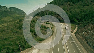 Aerial view of a fuel tank truck driving along the mountain road. Oil or gasoline transportation