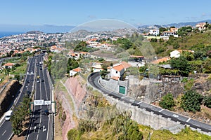 Aerial view of Funchal and highway, build against the mountains of Madeira Island