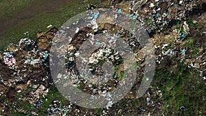 Aerial view of garbage pile in green field. Environmental concept. Drone footage.