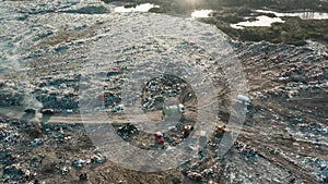 Aerial view of garbage truck driving at landfill. Dump of unsorted waste garbage pile in trash dump. Environmental