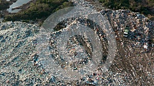 Aerial view of garbage truck unload pile of waste at landfill with cows. Dump of unsorted waste garbage pile in trash