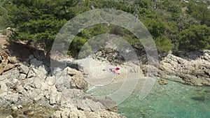 Aerial view girl alone on the beach in a beautiful landscape sunbathing.