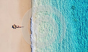 Aerial view of a girl on the beach on Bali, Indonesia. Vacation and adventure. Beach and turquoise water. Top view from drone at b