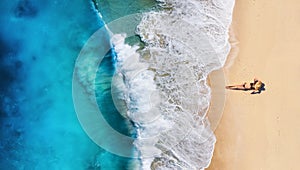 Aerial view of a girl on the beach. Beach and turquoise water. Top view from drone at beach, azure sea and relax girl. photo