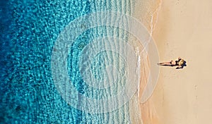 Aerial view of a girl on the beach. Vacation and adventure. Beach and turquoise water. Top view from drone at beach, azure sea and